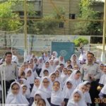 عکس گروهی دانش‌آموزان دختر و اساتید در حیاط مدرسه