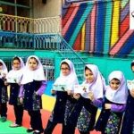 گروهی از دانش‌آموزان دختر بافرم مدرسه و حجاب سفید در حیاط مدرسه، در حال جمع‌آوری برای یک فعالیت یا مراسمی