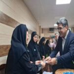مدیر یا مسئول مدرسه در حال تقدیر و تشویق دانش‌آموزان دختر در راهروی مدرسه با دیوارهای پانل‌دار چوبی