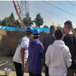 دانش‌آموزانی که با کلاه ایمنی آبی در حال بازدید و مشاهده یک سایت ساخت‌وساز و پروژه معماری‌ای هستند