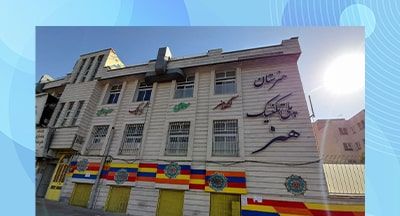 نمای خارجی ساختمان دبیرستان فنی ایران با سردر معماری و تزئینات رنگی دائمی