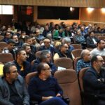 جمعی از شرکت‌کنندگان در حال حضور در یک مراسم یا اجتماع در سالن سخنرانی مدرسه