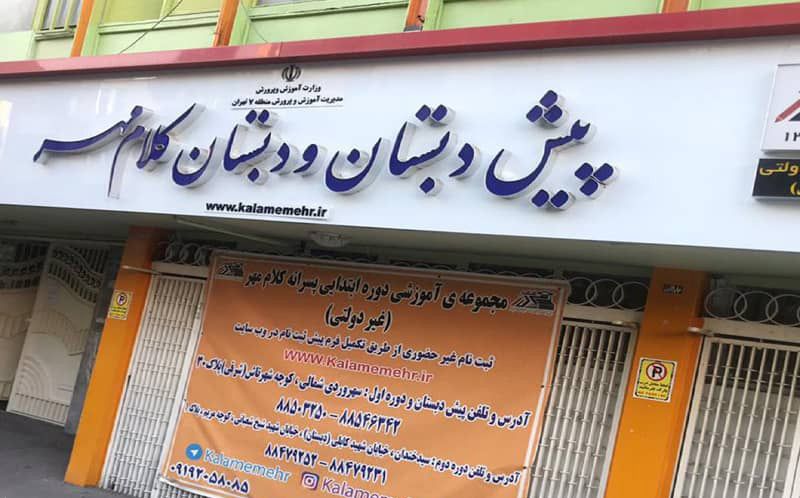 تابلوی ورودی مدرسه با نام و وبسایت و اطلاعات تماسی، کنار علامت پارکینگ ممنوع