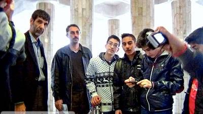 تجمع گروهی از کارکنان و مسئولین مدرسه در راهروی ساختمان برای یک رویداد یا جلسه اداری