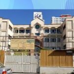 نمای جلوی ساختمان مدرسه با معماری سنتی، درب‌های فولادی و نماچین سفید