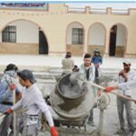 دانش‌آموزانی در حال انجام پروژه ساخت‌وساز گروهی در حیاط مدرسه، درحال کار با بتن و ملات‌ریزی در یک فعالیت عملی تعاونی