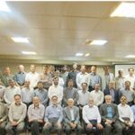 گردهمایی رسمی معلمان و کارمندان مدرسه خاجه نصیرالدین طوسی برای عکس یادگاری در یک اتاق اداری