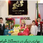گروهی از دانش‌آموزان و معلم در رویدادی بهاری با دکوراسیون گل و پرچم‌های ملی ایران