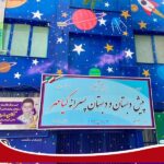 نمای بیرونی سردر ساختمان مدرسه با تابلوی رسمی و طراحی تزئینی فضا و ستارگان