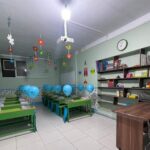 فصل درس مزین شده با بالونهای آبی و تزیینات رنگی معلق برای یک مراسم و احتفالیه در مدرسه