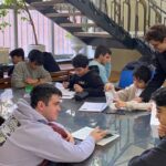 دانش‌آموزان در حال انجام فعالیت تعلیمی تحت راهنمایی معلم در کلاس درس