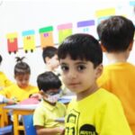 دانش‌آموزان کوچک در حال انجام یک فعالیت هنری خلاقی با ساخت اشکال کاغذی رنگی