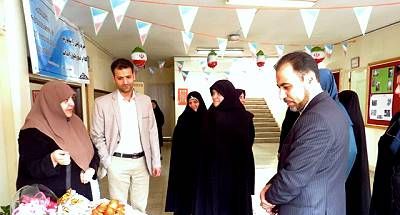 دانش‌آموزان و مهمانان در یک مراسم مدرسه‌ای با تزئینات آویز و میز غذایی