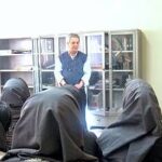 دانش‌آموزان و معلم در یک جلسه‌ی گروهی و بحث داخل کلاس درس، نشسته در حلقه برای تبادل نظر و فعالیت تعاونی