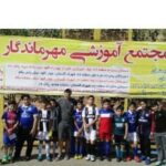 گروه دانش‌آموزان مجتمع آموزشی مهرمندگار در حال عکس‌یادی در مقابل بنر مدرسه