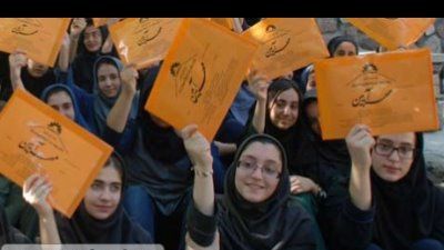 دانش‌آموزانی در حال شرکت در یک فعالیت گروهی که کاغذ‌های نارنجی رنگی در دست دارند