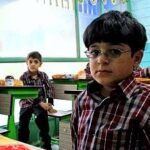 گروهی از دانش‌آموزان در حال فعالیت‌های تعلیمی مختلف در کلاس درس با میزهای سبز
