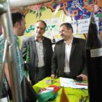 مسئولان مدرسه در حال کاشف‌کردن یک نمایشگاه یا برنامه‌ی رسمی با تزئینات و پرچم ملی