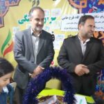 مسئولین مدرسه و دانش‌آموزان در حال بازدید از نمایشگاه هنری با آثار هنری سنتی ایرانی