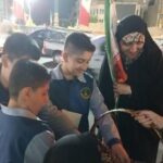 دانش‌آموزان مدرسه در حال شرکت در یک فعالیت آموزشی علمی عملی در فضای خارج ساختمان با نظارت معلمین و والدین