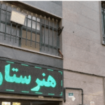 نمای بیرونی ساختمان مدرسه هفت شهر با صفحه نمایش LED سبز، سه پنجره با میله فولادی و دیوار خاکستری