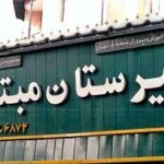 نمای بیرونی ساختمان دبیرستان با تابلوی نام مدرسه روی درب ورودی