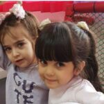 دو دانش‌آموز در حال شرکت در فعالیت بازی درون‌ساختی با درب قرمز و توری فلزی در پس‌زمینه