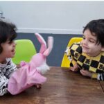 دانش‌آموزان در حال اجرای فعالیت آموزشی با عروسک صورتی در کلاس‌درس
