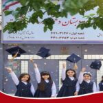 دانش‌آموزانی با لباس فرم و کلاه فارغ‌التحصیل در حال پرتاب کلاه‌ها در مراسم جشن دیپلم‌ آوری مدرسه