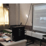 دانش‌آموز در حال کار روی رایانه با صفحه نمایش بزرگ در کلاس یا سایت کامپیوتری مدرسه