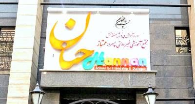 نمای خارجی سردر ورودی مدرسه ممتاز‌خانان با تابلوی رنگی در واجهه ساختمان