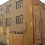 نمای جلوی ساختمان مدرسه با نما کتاری قهوه‌ای و درب ورودی معماری