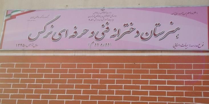 تابلوی فارسی ورودی مدرسه با نام و اطلاعات تاریخی بر روی دیوار آجری قرمز