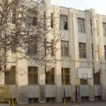 نمایی از ساختمان اصلی با معماری کلاسیک و درهای فلزی رنگی