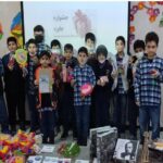گروهی از دانش‌آموزان در حال شرکت در یک فعالیت هنری و خلاقانه، با نمایش اشیاء و تزئینات رنگی دست‌ساز روی دیوار