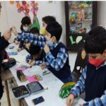 معلم و دانش‌آموزان در حال انجام فعالیت کاردستی و هنری، ایجاد آثار دستی و کاری گروهی در کلاس درس