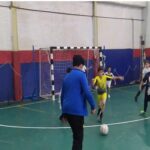 دانش‌آموزان در حال بازی هندبال در سالن ورزشی داخلی