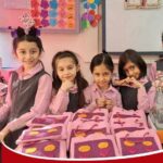 چهار دانش‌آموز دختر در حال انجام یک پروژه تحقیقی با صفحات پتری و نمونه‌های زیستی رنگی در کلاس درس