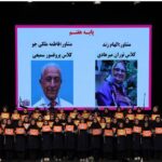 دانش‌آموزان پایه هشتم در مراسمی رسمی، در حضور مدیران مدرسه که تصاویر آن‌ها روی صفحه‌ی بزرگ نمایش داده می‌شود