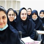 دانش‌آموزان دختر در کلاس درس، نشسته‌اند و برای عکس گروهی پوز می‌دهند