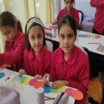 دانش‌آموزان دختری در حال انجام پروژه‌ی هنری و خلاق با اشکال و رنگ‌های مختلف در کلاس درس