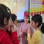 دانش‌آموزان در حال شرکت در یک فعالیت گروهی و تعاملی در کلاس درس، یکی از آنها با تاج تزئینی