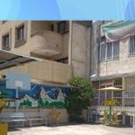 حیاط مدرسه با درختچه‌ها، گیاهان، و ساختمان‌های آجری