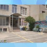 نمای خارجی ورودی اصلی مدرسه با درب ورودی، پله‌ها، و حیاط فضای باز