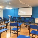 کلاس درس دبیرستان دخترانه نواندیشان هیوا با نیمکت‌های آبی و تخته وایت‌برد