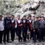 گروه دانش‌آموزان در طی یک فعالیت بیرونی و اردو درمیان صخره‌های کوهستانی