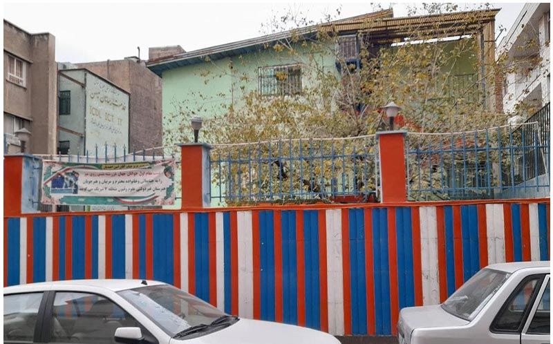 نمای بیرونی سردر و ورودی ساختمان با دیوار رنگی آبی، قرمز و سفید و پنجره‌های نقره‌ای