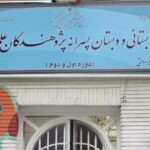 سردر ورودی ساختمان مدرسه با تابلوی آبی شامل نام مدرسه و تزیینات دیواری رنگی