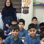 معلم و شاگردان پسری در کلاس درس به هنگام عکس گروهی