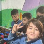 دانش‌آموزانی در حال بازی فوتبال دستی در سالن ورزشی مدرسه